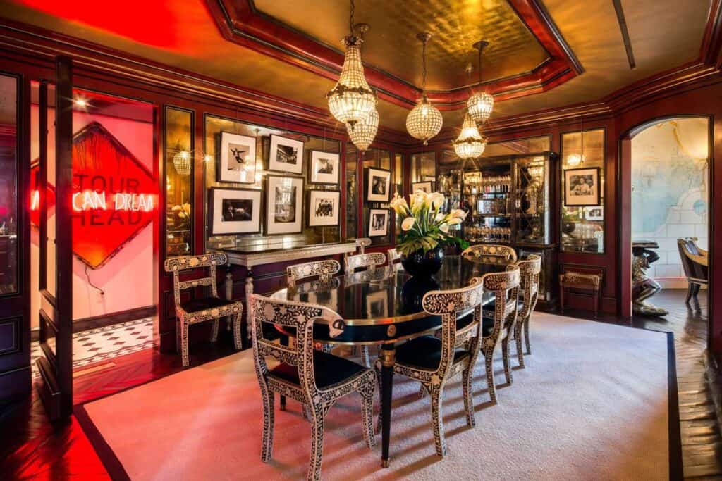 Luxury elegant dining room with chandeliers and framed black-and-white photos, sophisticated interior design, rich wood paneling, and decorative accents for upscale dining experience.